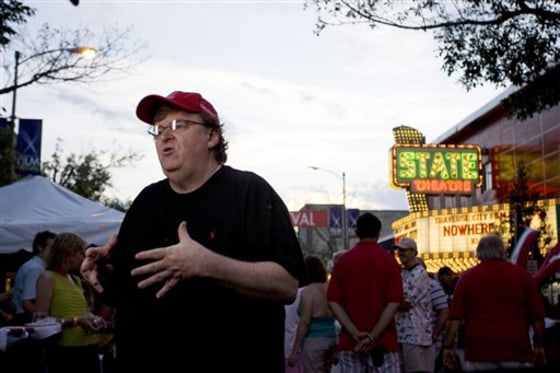 Documentary director Michael Moore near a Traverse City, Mich., movie theater he helped save and renovate. He hopes to expand the effort to more downtown theaters nationwide.